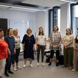 Der Hochschulechor in kreis aufstellung im Probenraum