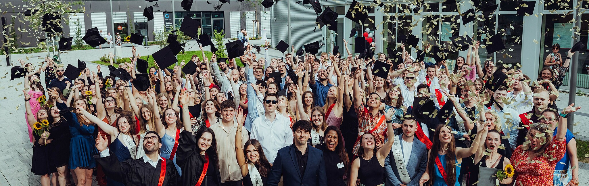 Absolventen beim Werfen der Alumnihüte