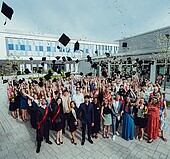 Absolventen beim Werfen der Alumnihüte