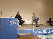 Moderator Prof. Peter Rahn mit Referent Jörg Alt auf der Bühne des Vortragssaals im Ernst-Bloch-Zetrum. 
