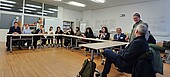 Die Delegation aus Usbekistan und Vertreter*innen der HWG LU diskutieren in einem Konferenzraum.