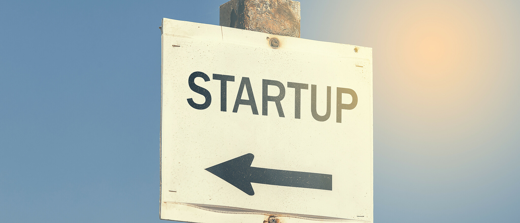 Ein Schild auf dem "Startup" steht, mit einem Pfeil, der nach links zeigt.